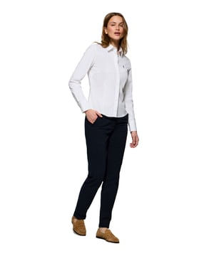 Peppen Sie Ihren Look mit unserem Slim-Fit-Hemd auf, das sich perfekt für Frauen eignet, die auf der Suche nach einem lässigen Alltagsoutfit sind. Es ist aus weicher Baumwollpopeline gefertigt und bietet die perfekte Mischung aus Komfort und Eleganz. Der französische Kragen und der Knopfverschluss sorgen für einen sauberen, schnittigen Look. Kontrastfarbene Paspeln am Kragen und Verzierungen an den Seitennähten veredeln den klassischen Stil mit einem raffinierten Touch. Die Logoknöpfe und das horizontal genähte Knopfloch sind das i-Tüpfelchen des raffinierten und sorgfältigen Designs. Das ikonische Rigby Go Logo auf der Brust verleiht ihm eine einzigartige Note.
