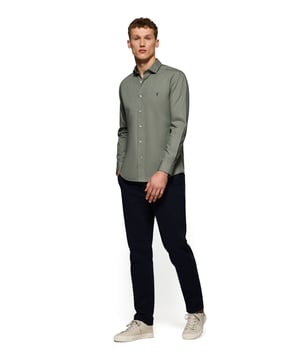 Unser Hemd im Slim Fit ist für den Mann gedacht, der Stil und funktionelles Design sucht. Aus leichter Baumwoll-Popeline gefertigt, eignet es sich ideal für den Alltag oder für formellere Anlässe. Der italienische Kragen verleiht ihm einen Hauch von Raffinesse. Kontrastfarbene Paspeln am Kragen und Verzierungen an den Seitennähten veredeln den klassischen Stil mit einem raffinierten Touch. Die Logoknöpfe und das horizontal genähte Knopfloch sind das i-Tüpfelchen des raffinierten und sorgfältigen Designs. Das kultige, gestickte Rigby Go-Logo in Kontrastfarbe auf der Brust verleiht ihm eine einzigartige Note.