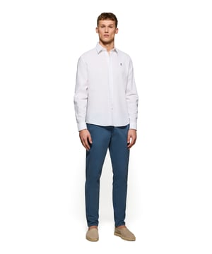 Dieses für jeden Anlass perfekte Hemd mit regulärer Passform kombiniert frisches Leinen mit weicher Baumwolle. Das Design der Passform und des französischen Kragens passt sowohl gut zu legeren als auch formellen Looks. Liebevolle Details, wie die Knöpfe mit Markenlogo, die Stickerei des Endknopflochs in Farbe des Logos sowie kontrastfarbene Paspeln an der Innenseite des Kragens und der Manschetten, betonen den exklusiven Charakter dieses Hemds. Die klassische Rigby Go Stickerei auf der Brust rundet das Design ab.