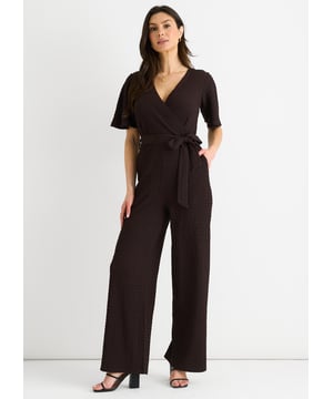 Verwen jezelf met luxe in onze Chocolate Textured Jersey Jumpsuit. Het wikkelontwerp voegt verfijning toe terwijl de wijde pijpen zorgen voor een flatterend silhouet. De getextureerde jersey stof voegt een vleugje elegantie toe. Deze jumpsuit is perfect voor elke gelegenheid en een must-have voor de modebewuste vrouw.