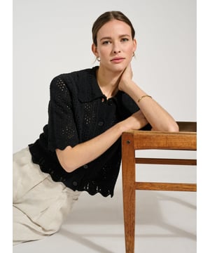 Description\nFits true to size, we suggest ordering your usual size.\nWe’re so in love with Pearl that we’ll be wearing it at every given opportunity! Either as a light cover-up over a  or as a top with a vest underneath. This crochet-style cardigan is cut for a short, boxy fit, and adorned with scallop edges around the collar hem. Best of all, it’s made from ECOTEC®, a recycled yarn with a low carbon footprint.\n\nMade in Europe\nCrafted in ECOTEC®\nOpenwork knit detail\nButtons down\nLoose, elbow-length sleeves\n\n\nSustainable Attributes:\n  Low Impact   Low Water Use  Recycled Fibres   Ethically made  Vegan   Low Carbon \n\nDetails\nModel is 5'10 (177cm) and is wearing a UK 1075% ECOTEC® Cotton, 20% ECOTEC® Polyester, 5% Other fibresHand Wash or Dry Clean OnlyProduct Code: KW40283-BLKCentre back waist to hem - 48cm (18 7/8)Sleeve length - 30cm (11 7/8)