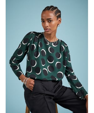 Description\nDottie is a printed blouse that is smart, comfortable and versatile. And will deliver when it comes to dressing for work or dinner. With its shadow spot pattern and beautiful drapey fabric, she won’t let you down. Wear it with tailored trousers for a look that’s as effortless as it is elegant.\n\nMade in Europe\nCrafted in Livaeco viscose\nRouleau loop button back neck fastening\nPleat detailing around shoulders\nRelaxed fit\n\n\nSustainable Attributes:\n  Low impact  Low Water Use   Recycled Fibres   Ethically made  Low Carbon \n\nDetails\nModel is 5'10 (177cm) and is wearing a UK 10100% LivaecoDelicate Machine Wash 30˚Product Code: TP40797-GSSBack shoulder at neck to hem - 62cm (24 2/5)Sleeve length - 62cm (24 3/8)