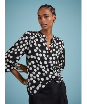 Description\nFits large to size, we suggest sizing down from your usual size.\nOne of our most popular - and elegant - blouse shapes brought to you in a timeless polka print. We love how the Jaqueline instantly elevates the simplest of jeans or trousers in one easy move, thanks to rouleau loop button fastenings, gathered shoulders and deep cuffs. Made from sustainable crepe fabric, it comes in a relaxed fit so it can easily be tucked in.\n\nMade in Europe\nCrafted in viscose crepe with Lenzing™ EcoVero™\nButton-through\nRelaxed fit\n\n\nSustainable Attributes:\n  Low Impact   Low Water Use  Ethically made  Low Carbon \n\nDetails\nModel is 5'10 (177cm) and is wearing a UK 1051% Lenzing™ EcoVero™ Viscose, 49% RCS ViscoseDelicate Machine Wash - 30°Product code: SH40297-BPABack shoulder at neck to hem - 64.cm (25 2/4)Sleeve length - 63.5cm (25)