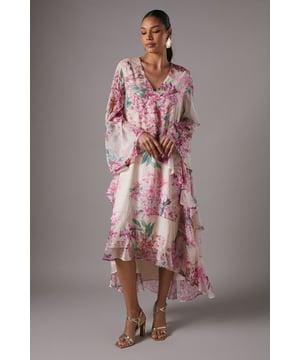 Flowing chiffon maxi dress with captivating floral print throughout
        Elegant V-neckline frames the dcolletage beautifully
        Dramatic volume sleeves add a touch of romance and sophistication
        Tiered, asymmetric hem creates graceful movement with high-low detail
        Lightweight, floaty fabric with full lining for comfort and coverage
    
    Make an unforgettable entrance at your next special occasion in this stunning Coast chiffon maxi dress. The flowing silhouette with its cascading layers creates a beautifully feminine profile that moves gracefully with every step. The striking floral print and voluminous sleeves convey a sense of refined drama, whilst the V-neckline adds a touch of allure. Style with metallic strappy heels and statement earrings as shown for wedding guest perfection, or pair with an elegant clutch for race day sophistication. The high-low hemline offers a contemporary twist on classic occasion wear, ensuring you stand out for all the right reasons. This versatile piece transitions effortlessly from daytime garden parties to evening celebrations, making it a worthy investment for your occasion wardrobe.