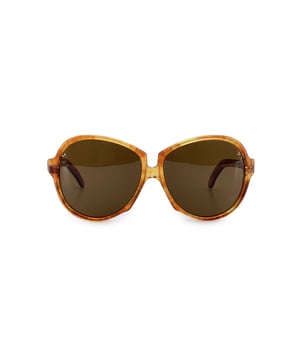 Empfohlener Verkaufspreis
Die mutige Muse: Vintage-Sonnenbrille GAUDE von Yves Saint Laurent aus den 1980ern. Lassen Sie den furchtlosen Geist der Haute Couture der 1980er mit dieser Vintage-Sonnenbrille GAUDE von Yves Saint Laurent aufleben, einem Statement-Piece, geboren in einer Ära kompromisslosen Glamours und markanter Silhouetten. Mit ihrem übergroßen Rahmen aus braunem Kunststoff verströmen sie das selbstbewusste, skulpturale Flair, das das Jahrzehnt prägte – und den visionären Stil von YSL selbst. Das seltene Modell GAUDE – 58/17, in Frankreich gefertigt, ist ein echter Sammlerfund. Kühn und doch elegant sind die Bügel mit dem charakteristischen YSL-Logo versehen, das ihnen diesen unverwechselbaren Pariser Touch verleiht. Die braunen Gläser ziehen nicht nur die Blicke auf sich, sondern bieten 100 % UV-Schutz und höchste optische Qualität – Stil und Substanz, die perfekte Kombination. Ob am Pool getragen oder als i-Tüpfelchen Ihres Vintage-Looks, diese Sonnenbrille fängt die Essenz der 1980er ein: gewagt, glamourös und unvergesslich. Zustandsbewertung: A – AUSGEZEICHNET. Zustandsdetails: Wenig verwendet. Gläser und Rahmen in ausgezeichnetem Zustand. Bitte überprüfen Sie die Bilder sorgfältig. Einige zeigen Pfeile an, die auf offensichtliche Mängel hinweisen. Bitte fragen Sie nach, wenn Sie weitere Details benötigen oder Fragen haben. Maximale Brillenbreite: 140 mm, Bügellänge: 140 mm, Maximale Brillenglasbreite: 58 mm, Maximale Brillenglasbreite: 57 mm, Stegbreite: 17 mm, Maße: Breite: 140 mm, Höhe: 57 mm