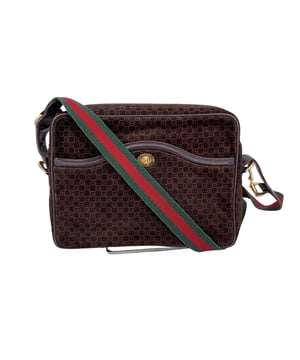 VINTAGE, RRP AS NEW
Step back in time with this exquisite vintage Gucci shoulder bag, a true testament to timeless style and exceptional craftsmanship. Made in Italy, this piece features a rich brown suede and brown leather exterior adorned with the iconic Gucci monogram pattern, a subtle yet unmistakable signature of luxury. The zip closure ensures your belongings are secure, while the front pocket with a twist closure adds both functionality and a touch of charm.  The bag's striking web canvas shoulder strap, with its beautiful gold metal decorations along the sides, is a nod to Gucci's storied heritage and bold design choices. Inside, the beige suede lining offers a soft contrast to the exterior, with a handy side zip pocket for added organization. The 'Made in Italy by Gucci' tag is a reminder of the bag's superior craftsmanship and its place in fashion history.  This vintage Gucci bag effortlessly blends practicality with elegance, making it a must-have for any collector or fashion enthusiast. Its combination of classic design elements and luxurious Condition Rating: B - VERY GOOD CONDITIONCondition Details: Gently used. Some normal wear of use on suede. Some normal wear of use on leather trim. Some darkness on the internal lining. Please check the photos carefully and ask if you need to know more details or if you have any doubts.Measurements (cm):Depth: 7.0Height: 19.1Length: 27.9Other Details: Dustbag? NoKeys? NoBox? No Measurments:  width: 70 mm length: 279 mm height: 191 mm