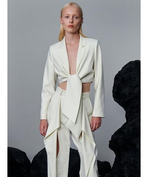 Es handelt sich um ein kurz geschnittenes Modell im modernen Stil mit Bindeband vorne. Die Jacke, die durch ihren tiefen V-Ausschnitt die Blicke auf sich zieht, endet an der Taille und bietet einen eleganten Look. Dieses Modell mit langen Ärmeln spiegelt zusammen mit seiner körperbetonten Struktur Eleganz und Schlichtheit wider. Während das Schnürdetail der Jacke eine dynamische Atmosphäre verleiht, zeigt sie mit ihrem minimalistischen Design eine schlichte, aber selbstbewusste Haltung.

Material: Hergestellt aus Stoff mit 66 % Polyester, 33 % Viskose, 1 % Elasthan.

Maße des Models: Sie trägt Größe S, ist 177 cm groß und hat die Maße 84/61/90 cm.