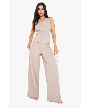 Tall wide leg trousers with elegant front pleats for added dimension and movement
        High-rise waistband with subtle stretch for all-night comfort
        Flowing wide leg silhouette creates a dramatic, fashion-forward profile
        Practical side pockets perfectly positioned for convenience
        Designed specifically for taller frames with extended length for proper fit
    
    Make a statement with these sophisticated wide leg trousers, designed with the taller fashionista in mind. The front pleating adds a touch of tailored refinement whilst the flowing wide leg cut creates a dramatic silhouette that commands attention. Perfect for evening socials, pair with the matching button-front top as shown for a coordinated ensemble that works brilliantly for drinks at upscale venues. For club nights, style with strappy heels and a cropped top to showcase the high waistband. The versatile design transitions effortlessly from casual drinks to more glamorous affairs-simply switch your accessories to match the occasion. These trousers offer the perfect balance of comfort and style for the Boohoo girl who wants to stand out whilst dancing the night away.