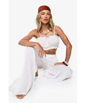 Textured crinkle-effect two-piece palazzo set with adjustable spaghetti straps
        Elasticated ruched crop top with feminine gathered neckline
        Flowing wide-leg palazzo trousers with comfortable elasticated waistband
        Relaxed, breezy silhouette perfect for warm-weather destinations
        Versatile co-ord that can be styled together or as separates
    
    Make a statement on your next beach getaway with this effortlessly chic palazzo two-piece. The textured crinkle-effect fabric adds visual interest whilst maintaining a lightweight feel that's ideal for hot climates. Style with a terracotta headscarf and layered necklaces for a bohemian beach look, or pair with metallic sandals and a woven bag for seaside lunches. The crop top can be mixed with denim shorts for casual daytime exploring, whilst the palazzo trousers work brilliantly with a simple bandeau for evening drinks by the sea. This versatile set transitions seamlessly from poolside lounging to beachfront dining - simply add oversized sunglasses and statement jewellery to complete your holiday ensemble. Perfect for packing light without compromising on style.