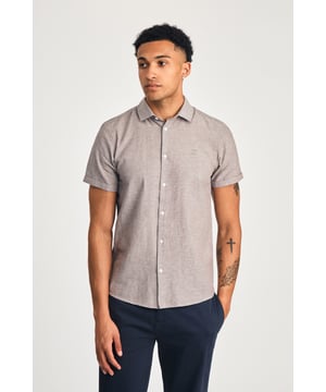 This short sleeve cotton-linen mix shirt by Nines features a sleek embroidered logo on the chest. Lightweight and breathable, it’s perfect for warm days. A stylish and comfortable addition to your wardrobe, offering the ideal balance of relaxed yet refined style.