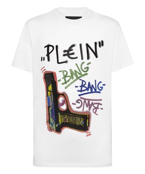 Dit grafische T-shirt is ongegeneerd brutaal en straalt rauwe energie uit met op graffiti geïnspireerd artwork en de kenmerkende kristallen details. Een onverschrokken fusie van kunst, attitude en luxe vakmanschap.    Past het best bij cargos of onder oversized bovenkleding Premium katoenen constructie met een zachte, gestructureerde hand Met de hand aangebrachte kristallen verheffen de street-art graphic Graffiti-belettering en geweermotief voor maximale visuele impact Een opvallend stuk dat edgy, high-end streetwear definieert