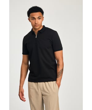 This zip-neck polo shirt from Kensington Eastside blends classic sophistication with modern design. Lightweight and breathable, it’s a versatile choice for smart-casual occasions, ensuring style and comfort effortlessly.