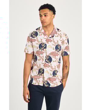 This resort-style shirt by Nines features a cool eagle and blossom print, adding a stylish look to your summer wardrobe. Lightweight and breathable, it's perfect for holidays or sunny days. A standout piece that effortlessly combines comfort and style for a laid-back, eye-catching look.