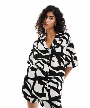 Tops by ASOS DESIGN Style with sunshine All-over print Revere collar Button placket Chest pocket Drop shoulders Oversized fitSold By: Asos
