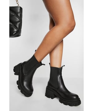 Chunky heeled Chelsea boot with a 7.5cm heel height
        Robust, cleated sole for enhanced grip and durability
        Elastic side panels for easy slip-on and off
        Sleek, rounded toe design
        Pull tab at the back for convenient wear
    
    Step out in style with these edgy chunky heeled Chelsea boots. The perfect blend of comfort and fashion-forward design, these boots are a must-have for the trendsetting Boohoo girl. The mid-height 7.5cm heel adds a touch of elevation without sacrificing walkability, making them ideal for all-day wear. Style them with cropped jeans and an oversized jumper for a casual daytime look, or pair them with a mini skirt and leather jacket for a night out with friends. The versatile design ensures they'll complement a variety of outfits, from family gatherings to impromptu coffee dates. The cleated sole not only adds to the boot's bold aesthetic but also provides excellent traction for those unpredictable British weather days. With their sleek silhouette and edgy details, these Chelsea boots are set to become your go-to footwear for making a statement this season.