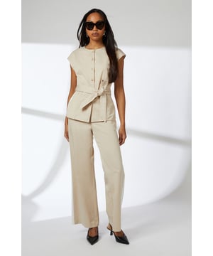 Elegant button-front waistcoat with distinctive round buttons for a refined finish
        Flattering cap sleeves that create a clean, contemporary silhouette
        Self-tie belt that cinches the waist for a customised fit
        Collarless neckline offering a modern, minimalist aesthetic
        Regular fit design ensuring comfortable all-day wear
    
    This versatile Principles waistcoat brings sophisticated structure to your daywear collection. The clean lines and button detailing create a polished look that works beautifully for various casual occasions. Style it as shown with matching wide-leg trousers for an effortlessly coordinated ensemble, or break it up with slim-fit denim and trainers for a more relaxed approach. The adjustable belt allows you to create definition at the waist, making it flattering for all body types. Perfect for family gatherings, brunch dates or gallery visits, this piece transitions seamlessly from day to evening when paired with statement jewellery and sleek mules. The breathable lyocell-cotton blend ensures comfort throughout the day, while the timeless design promises to remain a wardrobe staple for seasons to come.