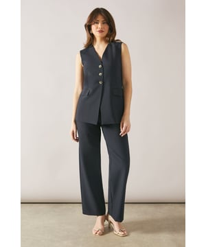 Sleek three-button waistcoat design
        Flattering V-neckline for a sophisticated look
        Versatile regular fit suitable for various body types
        Woven fabric with a touch of stretch for comfort
        Coordinating wide-leg trousers for a complete ensemble
    
    Embrace effortless sophistication with this three-button waistcoat from Wallis. Perfect for the woman who appreciates both style and comfort, this versatile piece is ideal for elevating your daywear wardrobe. The regular fit and V-neckline create a flattering silhouette, while the woven fabric offers a polished appearance with just the right amount of stretch for all-day ease. Style it with the matching wide-leg trousers and a crisp white blouse for a chic office look, or pair it with your favourite jeans and ballet flats for a smart-casual ensemble perfect for family gatherings or lunch with friends. Add a delicate necklace and stud earrings to complete your look with understated glamour. This waistcoat is a versatile staple that will quickly become your go-to piece for effortless, sophisticated style.