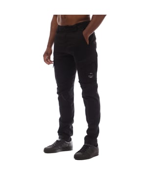 Mens C.P. Company Stretch Sateen Cargo Lens Pants in black.- Button and zip fastening.- Adjustable drawstring waistband.- Side pockets.- Cargo flap snap pockets.- Back flap snap pockets with applied logo label.- Belt loops.- Lens detail.- Garment dyed.- Ergonomic fit.- 98% Cotton  2% Elastane.- Ref: 18CMPA056A999