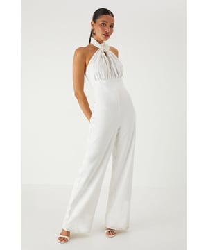 Striking halterneck design with elegant corsage detail for a dramatic neckline statement
        Structured corset bodice that creates a flattering silhouette
        Wide leg cut offering sophisticated movement and comfort
        Backless design for a show-stopping rear view
        Floor-length style perfect for formal occasions and evening events
    
    Command attention in this stunning MissPap halterneck jumpsuit that combines contemporary style with classic elegance. The corsage detail at the neckline creates a beautiful focal point, whilst the structured corset bodice sculpts and defines your figure. The flowing wide legs offer a graceful silhouette that moves beautifully as you walk. Style with statement earrings as seen on our model and strappy heels for a sophisticated ensemble perfect for weddings, graduation ceremonies or summer garden parties. For cooler evenings, drape a lightweight shawl over your shoulders to maintain the elegant aesthetic. This versatile piece transitions effortlessly from daytime formality to evening glamour, making it an essential addition to your occasion wardrobe.