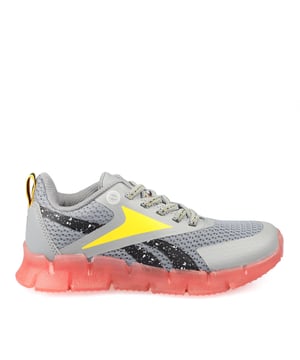 Juniors Reebok Zig N' Glow Elastische Sneakers in grijs. - Textielen bovenwerk. - Elastische veters. - Licht gewatteerde enkel. - Heel pull. - Licht gewatteerde binnenzool. - Rubber met stap-geactiveerde LED-lichtjes in de middenzool met aan-uit schakelaar. - Ref: 100213275