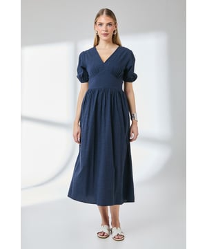 Elegant V-neckline with gathered detailing for a flattering silhouette
        Charming puff sleeves with elasticated cuffs for a feminine touch
        Fitted waistband creating a defined, structured shape
        Practical side pockets for everyday convenience
        Midi length design falling below the knee for versatile styling options
    
    This linen-look midi dress from Principles offers effortless style for your daytime wardrobe. The flattering V-neckline and puff sleeves create a feminine silhouette, while the fitted waistband accentuates your natural shape before flowing into a relaxed skirt. Style with flat sandals and a woven tote for weekend brunches or farmers' markets. For a more polished daytime look, pair with a denim jacket and trainers, adding statement jewellery like the model's cuff bracelet and drop earrings. The practical side pockets add functionality to this already versatile piece, making it perfect for garden parties, casual family gatherings, or leisurely afternoon teas. This dress transitions beautifully from spring through autumn with appropriate layering.