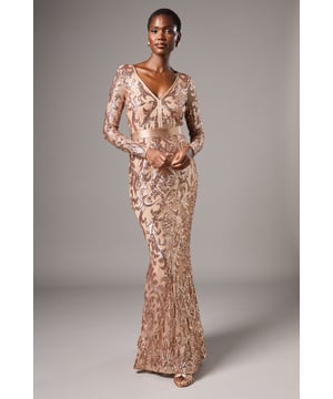 Striking sequin embellishment across intricate pattern detailing
        Elegant V-neckline frames the dcolletage beautifully
        Figure-enhancing maxi silhouette with floor-sweeping length
        Long sleeves offer sophisticated coverage for formal occasions
        Semi-sheer overlay creates a captivating contrast against the lining
    
    Make an unforgettable entrance in this show-stopping sequin maxi dress from Coast. The alluring V-neckline and body-contouring fit create a silhouette that commands attention, whilst the intricate pattern detailing adds depth and dimension to your look. Perfect for black-tie events, evening galas or wedding receptions, this dress requires minimal accessorising-simply pair with delicate drop earrings and a sleek clutch as seen on our model. The floor-length design creates a graceful sweep as you move, whilst the long sleeves provide an elegant balance to the striking neckline. Style with strappy heeled sandals and a tailored evening coat for cooler evenings. This dress transitions effortlessly from formal ceremonies to evening celebrations, ensuring you remain the epitome of sophistication throughout any special occasion.