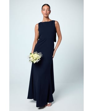 Elegant sleeveless design with a sophisticated boat neckline
        Stunning bow detail at the back creates a dramatic focal point
        Figure-flattering crepe fabric that sculpts and defines your silhouette
        Floor-length maxi style with a graceful flowing skirt
        V-shaped back detail adds a touch of refined allure
    
    This Coast bridesmaids dress combines timeless elegance with contemporary styling. The sleek silhouette gently skims your curves while the statement bow back detail creates a memorable impression as you walk down the aisle. Perfect for the bridal party seeking sophistication, this dress offers both comfort and style for your role in the wedding celebration. The crepe fabric drapes beautifully and maintains its shape throughout the day, ensuring you look impeccable from ceremony to final dance. Complete your bridal party ensemble with delicate drop earrings and an elegant updo as shown on our model, allowing the bow detail to take centre stage. A truly refined choice that will complement the bride while ensuring you feel confident and poised throughout the special day.