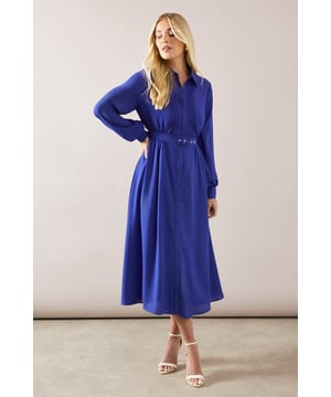 Elegant midaxi shirt dress with delicate lace trim detailing
        Classic collared neckline with front button fastening
        Flattering belted waist with matching buckle closure
        Sophisticated pleated front panel and billowing long sleeves
        Graceful A-line silhouette with gentle flowing skirt
    
    This sophisticated shirt dress combines timeless elegance with contemporary styling. The collared neckline and button-through design create a refined silhouette, whilst the matching belt cinches the waist for a flattering fit. The delicate lace trim adds a touch of femininity to this otherwise classic piece. Style with strappy heeled sandals as seen on our model for formal occasions such as weddings or race days. For a more versatile daytime look, pair with white trainers and a structured tote bag. The midaxi length offers the perfect balance between modesty and modern appeal, making this Wallis dress a wardrobe essential for the sophisticated woman who appreciates both comfort and glamour. The flowing fabric moves beautifully with every step, ensuring you feel as confident as you look whether attending a graduation ceremony or enjoying afternoon tea.