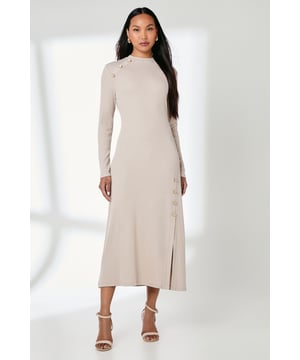 Elegant ribbed midi dress with distinctive button detailing along the shoulder and side
        Flattering crew neckline and long sleeves for versatile seasonal wear
        Figure-enhancing silhouette with a comfortable stretch blend fabric
        Sophisticated side split detail adds movement and contemporary flair
        Clean, minimalist design perfect for effortless day-to-night styling
    
    This Button Detail Rib Dress from Principles combines timeless elegance with modern design elements. The ribbed texture creates a subtle visual interest while the distinctive button detailing along the shoulder and side seam adds character to this refined piece. Style with strappy heeled sandals as shown for casual gatherings, or dress down with white trainers and an oversized denim jacket for weekend brunches. The midi length and side split offer both sophistication and ease of movement, making this dress ideal for family occasions or casual workplace settings. For cooler days, layer with a lightweight trench coat and ankle boots. Complete your look with simple gold-toned jewellery to complement the button detailing. This versatile dress transitions seamlessly from day to evening, offering endless styling possibilities throughout the seasons.