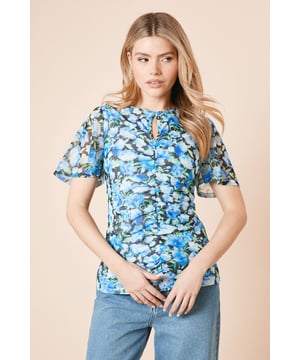 Elegant keyhole detail at the neckline adds a subtle touch of sophistication
        Flattering ruched front design creates a beautifully gathered effect
        Delicate angel sleeves offer graceful movement and modest arm coverage
        Mesh fabric overlay creates a light, airy appearance with floral patterning
        Regular fit silhouette ensures comfortable wear for all-day events
    
    This Dorothy Perkins floral mesh top combines comfort with effortless style for the modern woman. The keyhole neckline and ruched front detailing create a flattering silhouette, whilst the angel sleeves provide just the right amount of coverage with a feminine flair. Perfect for casual gatherings, this versatile piece pairs beautifully with wide-leg denim as shown, or with tailored trousers for a smart-casual look. The mesh overlay adds textural interest to your ensemble without overwhelming it. Ideal for weekend brunches with friends, family gatherings or baby showers where you want to look put-together yet relaxed. Complete the look with comfortable flats and minimal jewellery for daytime events, or dress it up with statement earrings for evening occasions.