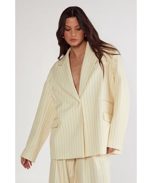 Tailored blazer featuring classic pinstripe pattern throughout
        Relaxed, oversized fit with structured shoulders for a contemporary silhouette
        Notched lapel collar with single-button fastening
        Functional front patch pockets for practicality and style
        Long sleeves with subtle cuff detail for refined finishing
    
    Command attention in the boardroom with this Nasty Gal Butter Pinstripe Tailored Blazer, a sophisticated workwear essential that balances professional polish with modern flair. The oversized proportions create a fashion-forward statement whilst maintaining workplace appropriateness. Style with the matching wide-leg trousers as seen on our model for a coordinated power suit, or break the set by pairing with tailored trousers and a crisp shirt for meetings. For casual Fridays, throw over a simple t-shirt with straight-leg jeans and loafers. The versatile design transitions seamlessly from day to evening - simply swap your work tote for a clutch bag and add statement jewellery for after-office gatherings. This blazer works brilliantly as a lightweight outerwear option during transitional seasons, making it a true wardrobe workhorse.
