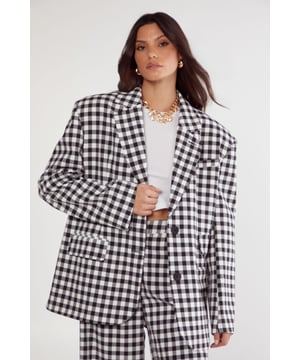 Tailored fit blazer featuring classic gingham pattern for a contemporary twist on traditional tailoring
        Structured shoulders and notched lapels create a refined silhouette
        Single-button fastening for a sleek, streamlined look
        Functional front pockets add practical detail to this statement piece
        Versatile design that can be styled as a coordinated suit or as a standalone statement piece
    
    This Nasty Gal gingham blazer brings a fresh perspective to tailored dressing. The classic check pattern offers a playful yet sophisticated aesthetic that works brilliantly for smart occasions. Style with the matching wide-leg trousers as seen on our model for a coordinated power suit that commands attention, or break up the look by pairing with tailored trousers in a solid hue. For daytime events, layer over a simple white tee with trainers for an effortlessly chic ensemble. For evening affairs, style with a silk camisole, statement jewellery and heels to create a look that transitions seamlessly from boardroom to bar. The oversized fit provides a contemporary silhouette that feels both on-trend and timeless - perfect for those who appreciate fashion-forward tailoring with versatile styling potential.