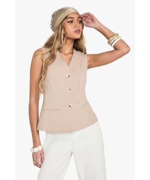Sleeveless waistcoat with elegant V-neckline for a flattering silhouette
        Linen-look texture adds dimension and visual interest to your outfit
        Structured button-front design with subtle waist definition
        Versatile sleeveless cut perfect for layering or wearing alone
        Clean-lined silhouette with a contemporary tailored finish
    
    This sophisticated waistcoat brings effortless chic to your everyday wardrobe. The linen-look texture creates a relaxed yet refined aesthetic that works brilliantly for various casual occasions. Style with wide-leg trousers as shown for a coordinated ensemble that's perfect for family gatherings or weekend brunches. For cooler days, layer over a fitted long-sleeve top or under a lightweight jacket. Complete the look with a patterned headscarf and stacked bangles for a bohemian touch, or keep it minimal with delicate jewellery for a more understated approach. The neutral tone makes this waistcoat incredibly versatile - pair with denim for an elevated casual look or with tailored pieces for smart-casual events. Machine washable for easy care, this piece combines style with practicality for the fashion-forward woman.