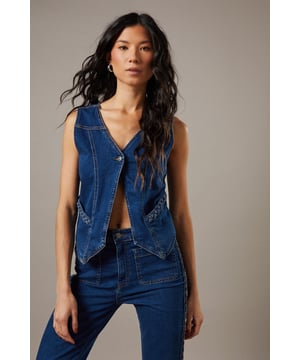 Boxy fit denim waistcoat with distinctive button front closure
        Sleeveless design with V-neckline for a feminine silhouette
        Contrast topstitching detail highlighting the structured seams
        Practical front pockets with decorative stitching
        Versatile co-ord piece that can be styled separately or as a set
    
    This Button Front Denim Waistcoat from Warehouse offers effortless edge to your casual wardrobe. The boxy silhouette creates a contemporary shape that pairs brilliantly with the matching flared trousers as seen on our model, or can be styled with your favourite denim jeans for a double denim moment. For daytime outings, layer over a simple white tee and finish with trainers and statement jewellery. When the evening calls, wear it unbuttoned over a fitted bodysuit and team with heeled boots for a touch of after-dark confidence. Perfect for festivals, weekend brunches or casual gatherings, this versatile waistcoat transitions seamlessly through the seasons - simply add layers underneath when temperatures drop. The cotton fabric ensures comfort whilst maintaining that structured denim look that never goes out of style.