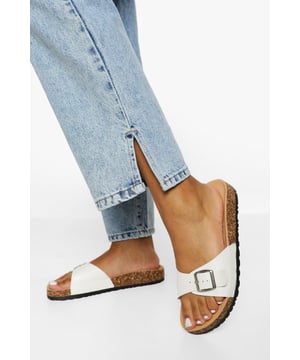 Stylish buckle footbed slider with adjustable strap
        Comfortable cork-effect footbed for enhanced support
        Flat heel between 0 and 2cm for easy all-day wear
        Versatile design suitable for various casual occasions
        Durable synthetic materials for long-lasting use
    
    Step into comfort and style with these trendy buckle footbed sliders from Boohoo. Perfect for the fashion-forward woman who values both aesthetics and practicality, these sandals are a must-have for your casual wardrobe. The adjustable strap ensures a customised fit, while the cork-effect footbed provides a natural, earthy look and superior comfort. Pair them with cropped jeans and a breezy top for a laid-back weekend brunch, or slip them on with a floaty sundress for a relaxed day at the beach. Their versatility makes them ideal for family gatherings, casual outings, or simply lounging at home. The flat heel offers stability and comfort for extended wear, making these sliders your go-to choice for effortless summer style that doesn't compromise on comfort.