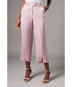 Tailored crop trousers with distinctive split front detail for a contemporary silhouette
        Elegant crepe fabric offering comfortable stretch and structure
        Flattering high-rise waistband with side pockets for practicality
        Sophisticated cropped length finishing at the ankle
        Versatile design perfect for formal occasions and professional settings
    
    These Split Front Crop Trousers from Coast present a refined option for your occasion wardrobe. The distinctive split detail at the front creates visual interest while maintaining a sophisticated aesthetic. Style with the matching tailored jacket for a coordinated ensemble that commands attention at weddings or race day events. For evening affairs, pair with a silk camisole and strappy heels, adding statement jewellery to complete your look. The tailored fit sculpts your silhouette beautifully while the cropped length showcases elegant footwear. These trousers transition effortlessly from daytime ceremonies to evening receptions, making them a versatile investment piece. The clean lines and contemporary design reflect Coast's commitment to elegant occasionwear that helps you look polished and poised for life's special moments.