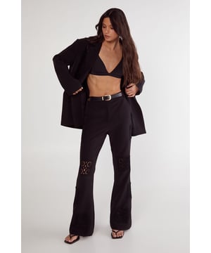 Tailored trousers featuring intricate crochet inserts at the knees for a distinctive design element
        Flattering flared silhouette that gracefully widens from the knee to create an elongated leg line
        High-rise waistband with belt loops, perfect for styling with statement belts
        Sleek side pockets for practical functionality without compromising on style
        Versatile design that transitions seamlessly from daytime sophistication to evening elegance
    
    These Nasty Gal tailored trousers redefine smart dressing with their artful crochet inserts that add textural interest to a classic silhouette. The flared leg creates a balanced proportion that flatters all figures, whilst the high-rise fit accentuates the waist beautifully. Style them as seen with an oversized blazer and minimal top for a contemporary take on tailoring, or pair with a crisp button-down shirt for more formal settings. The trousers work brilliantly for sophisticated events where you want to make an impression without appearing overdressed. For evening occasions, team with a silk camisole and strappy heels, or dress down for smart-casual gatherings with a fitted turtleneck and elegant flats. The crochet detail ensures these trousers stand out from standard tailoring, making them a versatile investment piece for your wardrobe.