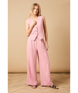 Tailored wide leg design with elegant front pleats for a flattering silhouette
        High-rise waistband with button fastening for a secure and comfortable fit
        Practical side pockets perfect for everyday essentials
        Flowing wide leg cut creates a graceful drape when walking
        Versatile woven fabric suitable for both formal occasions and smart-casual styling
    
    These sophisticated wide leg trousers from Oasis present the perfect balance of comfort and elegance. The tailored design features a flattering high waist that creates a sleek silhouette, whilst the generous wide leg cut offers a contemporary twist on classic formal wear. Style with the coordinating waistcoat for a chic two-piece ensemble perfect for summer weddings and race day events. For more relaxed occasions, pair with a simple silk camisole and metallic sandals as shown. The clean lines and structured fabric make these trousers an excellent choice for important meetings or graduation ceremonies, whilst their lightweight feel ensures you'll remain comfortable throughout the day. Add statement jewellery and a clutch bag to transform them into an evening-ready outfit that radiates refined femininity.