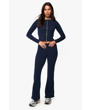 Ribbed two-piece co-ord featuring a zip-front crop top and flared trousers
        Stretchy, figure-hugging fabric with textured ribbed finish for added comfort
        Full-length sleeves and high neckline for versatile seasonal styling
        Flared trouser design creates a flattering silhouette
        Streamlined design with contrasting metallic zip detail on the top
    
    This ribbed co-ord set combines casual comfort with on-trend styling, perfect for those days when you want to look put-together with minimal effort. The zip-front crop top features a high neckline and long sleeves, whilst the flared trousers create a leg-lengthening effect that works brilliantly with trainers, as styled on our model. Wear together for a coordinated look at weekend brunches or family gatherings, or separate the pieces to maximise your wardrobe options. The top pairs wonderfully with high-waisted jeans for a casual coffee date, while the flared trousers can be dressed up with a fitted blouse for more polished occasions. The stretchy ribbed fabric moves with you throughout the day, making this set as practical as it is stylish.
