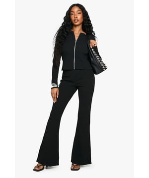 Textured ribbed jersey co-ord featuring a zip-through cropped top and statement flared trousers
        Contrasting stripe detail on cuffs adds a sporty, retro-inspired edge
        Figure-flattering silhouette with fitted top and dramatic flare from knee to hem
        Versatile two-piece design allows for mixing and matching with other wardrobe staples
        Stretchy fabric composition ensures comfort and ease of movement throughout the day
    
    Make a striking impression in this ribbed jersey co-ord from Boohoo. The zip-through top offers a contemporary twist on athleisure style, whilst the dramatic flared trousers create a leg-lengthening effect that commands attention. Perfect for casual outings, style with chunky trainers and a crossbody bag as seen on our model for daytime adventures, or dress up with statement earrings and platform heels for evening socials. The two-piece nature of this set provides excellent versatility-wear together for a coordinated look or separately to create multiple outfit options. The stretchy fabric moulds comfortably to your shape whilst maintaining its structure, making this the ideal ensemble for those who refuse to compromise on style or comfort.