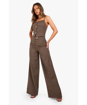 Textured straight-leg trousers with a contemporary wide silhouette
        High-waisted design with a sleek single button fastening
        Structured woven fabric that maintains shape throughout wear
        Clean-lined design with minimal detailing for versatile styling
        Full-length cut that skims over trainers for a modern look
    
    These textured straight-leg trousers offer effortless sophistication for your everyday wardrobe. The high-waisted design creates a flattering silhouette, whilst the wide-leg cut provides comfort and contemporary flair. Style with a fitted white top as shown for a balanced look, or pair with an oversized knit for cooler days. The structured fabric ensures these trousers hold their shape beautifully throughout the day. Perfect for casual gatherings or family events when paired with trainers and a coordinating blazer for a chic co-ord moment. For a more relaxed approach, team with a cropped tee and chunky jewellery. These versatile trousers transition seamlessly from daytime casual to evening drinks with a simple change of accessories and footwear.