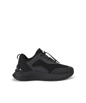 The Lisbon Sneaker arrives in black with a mesh fabric upper with rubber panels. The laces tie with a toggle adjuster and there is branding across the tongue.