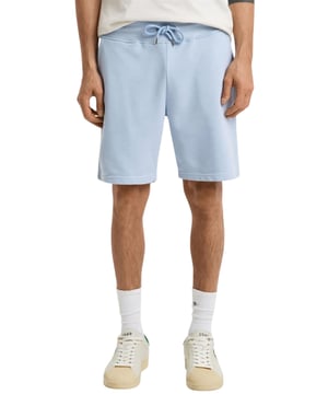 Estos clásicos pantalones cortos de chándal están confeccionados con una mezcla de algodón suave y diseñados para un ajuste regular. Con una cintura acanalada para mayor comodidad, el diseño incluye dos bolsillos frontales, un bolsillo trasero y una cintura con cordón. Para completar el look, los pantalones cortos están adornados con un pequeño escudo bordado en la pierna izquierda.