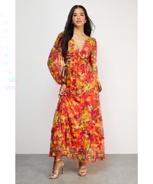Flowing chiffon maxi dress with eye-catching cut-out waist detail
        Elegant V-neckline complemented by feminine ruffle detailing
        Billowing long sleeves create a dramatic silhouette
        Flattering empire waistline enhances your natural shape
        Floor-sweeping maxi length perfect for special occasions
    
    This striking Warehouse chiffon maxi dress commands attention with its bold floral pattern and contemporary cut-out waist design. The lightweight, flowing fabric creates graceful movement as you walk, whilst the ruffle detailing adds a touch of romance to this sophisticated piece. Style with metallic strappy heels as seen on our model for formal events, or dress down with delicate flat sandals for garden parties. The versatile V-neckline allows for statement jewellery-try a pendant necklace or chandelier earrings to complete your ensemble. This dress transitions beautifully from summer weddings to autumn race days with the addition of a tailored blazer. The cut-out waist detail reveals just the right amount of skin, creating a balanced look that's both elegant and fashion-forward.
