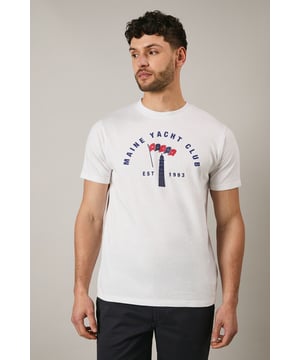 Classic crew neck t-shirt featuring the distinctive Maine Yacht Club graphic print
        Short sleeves with neat ribbed trim for a clean finish
        Soft jersey fabric offering comfort for all-day wear
        Vintage-inspired nautical design with established date detail
        Relaxed fit that's perfect for casual styling
    
    This Maine Yacht Club t-shirt combines timeless nautical charm with everyday wearability. The distinctive graphic print adds character to your casual collection, whilst the comfortable jersey fabric ensures it remains a go-to piece for relaxed days. Style as seen with dark shorts and white trainers for a classic summer look that works brilliantly for weekend brunches or coastal walks. For cooler evenings, layer under a lightweight bomber jacket or denim shirt. This versatile t-shirt transitions effortlessly from daytime casual to evening gatherings with friends - simply swap the shorts for chinos and add a casual blazer to create a smart-casual ensemble that maintains its laid-back appeal. Perfect for holidays, festivals or simply enjoying the British summer.