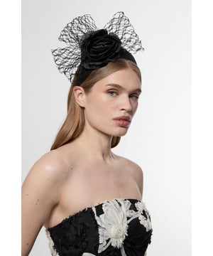 Make a statement at your next special event with this exquisite Karen Millen fascinator. The elegant rose-shaped centrepiece is complemented by flowing veil netting that adds drama and sophistication to your ensemble. Perfect for race day attire, this headpiece pairs wonderfully with a tailored dress or coordinated two-piece. For wedding guest styling, match with a structured midi dress and pointed court shoes for a refined look. The secure headband ensures your fascinator stays perfectly positioned throughout celebrations, whilst the intricate netting detail frames your face with a touch of vintage-inspired glamour. This versatile accessory transitions effortlessly from daytime ceremonies to evening receptions, adding that perfect finishing touch to your carefully curated outfit.  Striking rose-shaped centrepiece adorned with delicate veil netting Secure headband design Dramatic mesh veil detail Versatile fascinator suitable for races, weddings and formal occasions