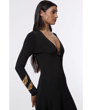 Make a statement at your next formal occasion with this captivating Karen Millen slinky knitted dress. The deep V neckline adorned with the signature hardware keyring detail creates a focal point that draws the eye, whilst the fluid knitted fabric drapes beautifully over your curves. Style with strappy metallic heels and a structured clutch for evening events, or dress down with embellished flat sandals for sophisticated daytime gatherings. The versatile design transitions seamlessly from wedding guest attire to race day ensemble, with the long sleeves offering coverage for cooler evening affairs. Add statement earrings and a sleek updo to showcase the elegant neckline, completing a look that commands attention whilst maintaining refined sophistication.  Striking V neckline with distinctive hardware keyring detail for a contemporary edge Elegant long sleeves with contrasting metallic accent detailing at the cuffs Flattering slinky knitted fabric that gracefully contours the silhouette Sophisticated maxi length with a subtle asymmetric hemline Figure-enhancing fit that creates a refined feminine profile