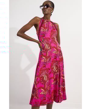 This captivating Karen Millen maxi dress showcases a vibrant floral print that demands attention whilst maintaining effortless elegance. The halterneck design frames the dcolletage beautifully, whilst the lace trim inserts add textural interest and a feminine touch. Style with oversized sunglasses and gold-toned drop earrings for daytime gatherings. The flowing silhouette works wonderfully for garden parties or family celebrations when paired with flat sandals and a woven clutch. For cooler evenings, layer with a lightweight denim jacket and switch to espadrille wedges. This versatile piece transitions seamlessly from casual brunches to sunset drinks, offering both comfort and style for your daywear collection. The woven fabric ensures a beautiful drape that flatters the figure whilst providing ease of movement.  Elegant halterneck design with delicate lace trim inserts Flowing maxi length Striking floral print woven fabric Sleeveless cut with open back detail Subtle keyhole detail