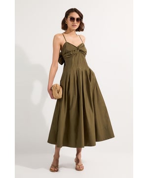 This Karen Millen sundress combines timeless elegance with contemporary design. The strapless bandeau neckline with its twisted front detail creates a flattering silhouette, while the optional spaghetti straps offer versatile styling options. The dramatic maxi length skirt provides graceful movement with every step, making it ideal for garden parties or seaside strolls. Style with flat leather sandals and a woven clutch for daytime gatherings, or dress it up with espadrille wedges and statement earrings for alfresco dining. The cotton fabric ensures comfort throughout the day, while the bow detail at the back adds a charming finishing touch. This dress works beautifully for casual summer events, family celebrations, or weekend brunches. It's a versatile piece that will become a warm-weather favourite in your wardrobe.   Strapless bandeau design with elegant twisted front detail Delicate spaghetti straps Flattering fitted bodice flowing into a voluminous maxi skirt Distinctive bow tie detail at the back