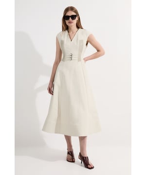 Four original pieces from the '00s archives, reworked into a modern-day collection. Paying homage to Karen Millen's design-led legacy, four archival design codes are reimagined and presented for SS25.  This Karen Millen cotton corset maxi dress marries vintage inspiration with contemporary design. The structured bodice features meticulous pintuck detailing and a striking triple-buckle grosgrain corset that defines the waist beautifully. The V-neckline frames the decolletage with understated elegance, while the voluminous A-line skirt creates a dramatic yet wearable silhouette. Style with strappy sandals as seen on our model for casual daytime events, or pair with trainers and a denim jacket for weekend brunches. For family gatherings, complement with delicate jewellery and a woven clutch. The cotton fabric offers breathability and comfort throughout the day, making this dress a versatile addition to your wardrobe that transitions effortlessly from garden parties to sophisticated lunch dates.   Elegant V-neckline with structured cap sleeves for a refined silhouette. Distinctive pintuck detailing on the bodice creates visual texture and dimension. Striking triple buckle grosgrain corset detail accentuates the waist. Practical side pockets discreetly integrated into the design. Voluminous A-line maxi skirt with pleating for graceful movement.